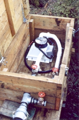 A micro hydro generator installed in a strong wooden housing.